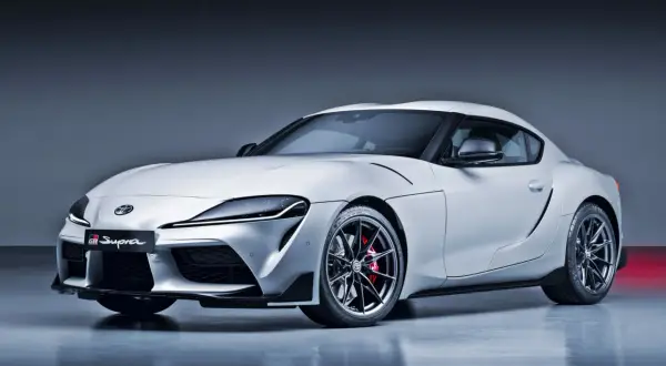 Biała Toyota Supra GR z czerwonymi zaciskami hamulcowymi. Ta sportowa marka samochodu na zdjęciu prezentuje dynamiczną sylwetkę.